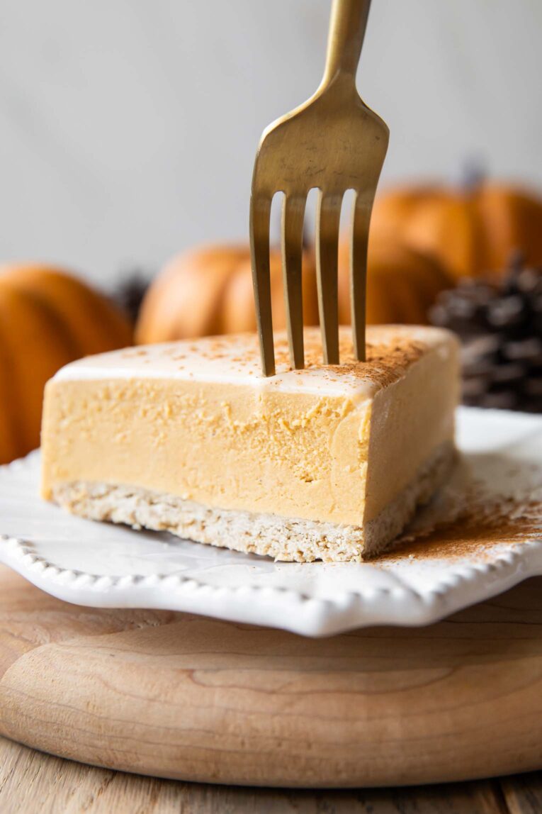 A slice of pumpkin cheesecake with a fork.