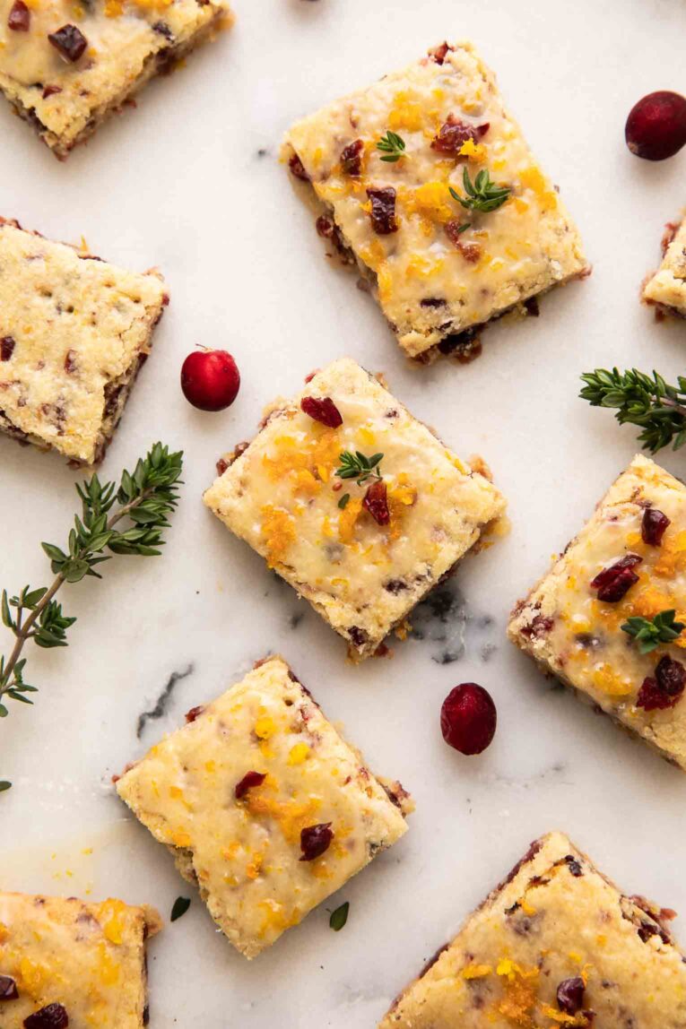 Cranberry orange bars on a white surface.