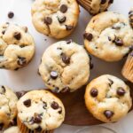 Banana chocolate chip muffins on a cutting board.