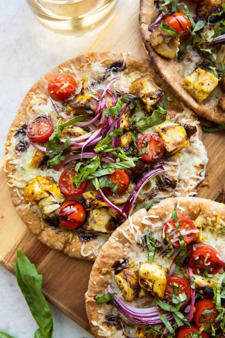 Mediterranean Chicken pizzas on a cutting board.