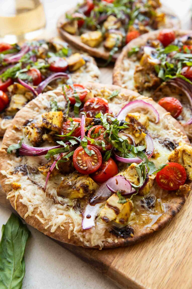 Mediterranean Chicken pizzas on a cutting board.