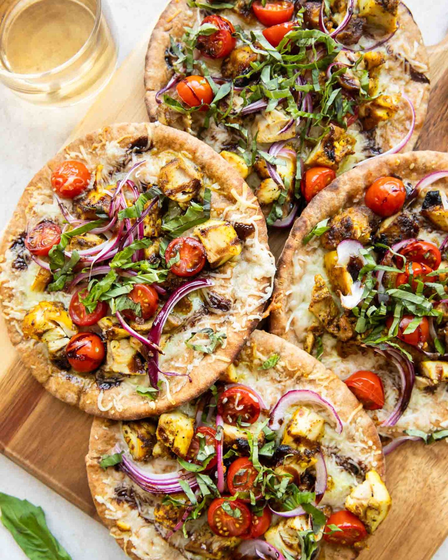Mediterranean Chicken pizzas on a cutting board.