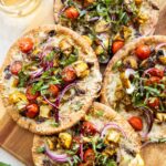 Mediterranean Chicken pizzas on a cutting board.
