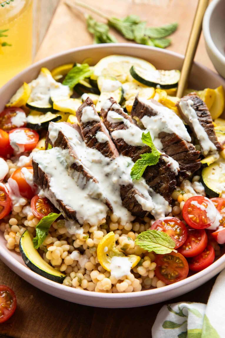 Close up of Steak Couscous Bowl on a cutting board.