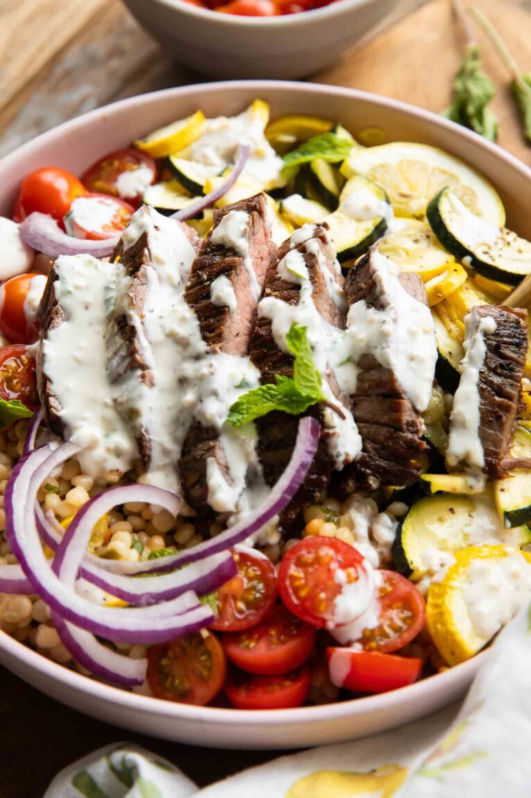 Angled view of Steak Couscous Bowl on a cutting board.