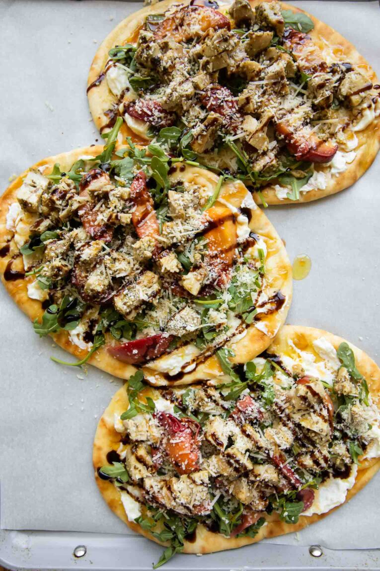 Balsamic Peach Chicken Flatbread pizza on parchment paper.