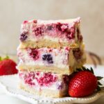 Greek Yogurt Cheesecake bars stacked on top of each other.