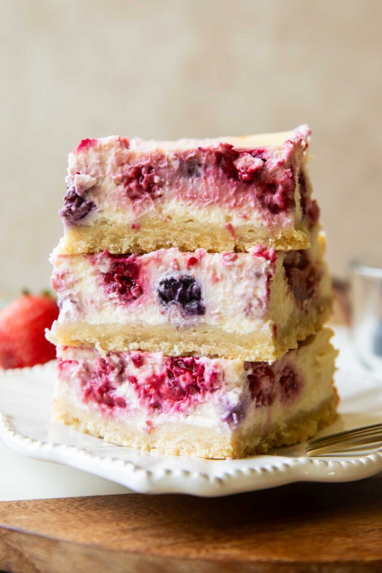 Greek Yogurt Cheesecake bars stacked on top of each other.