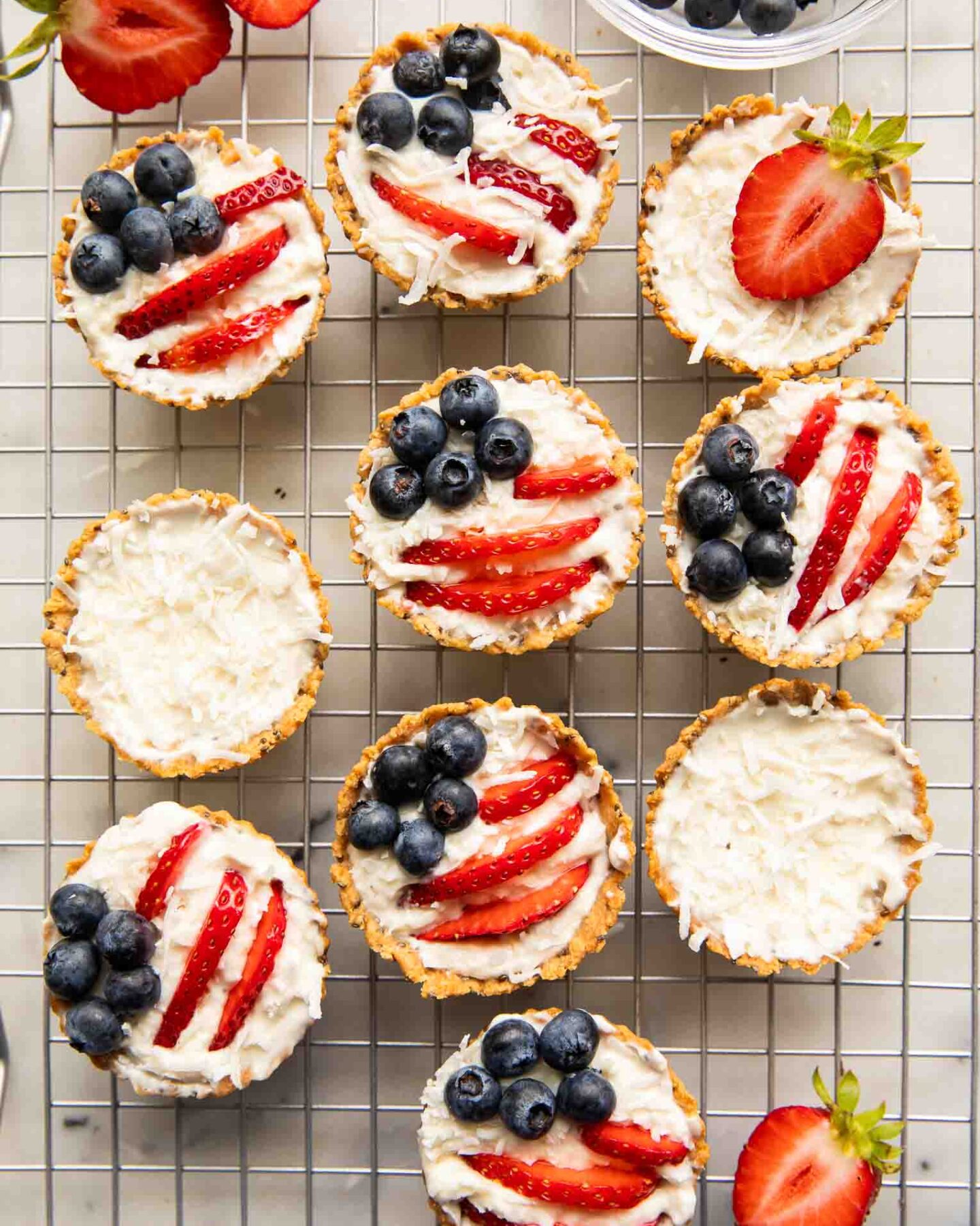 Patriotic fruit tarts on a cooling rack.
