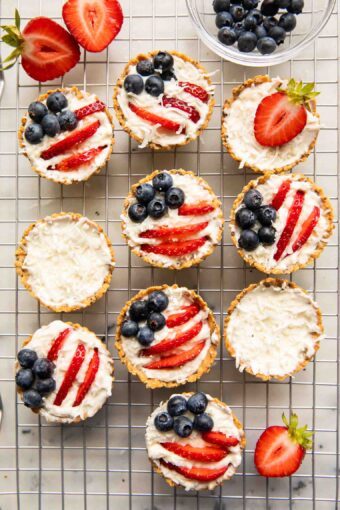Patriotic fruit tarts on a cooling rack.