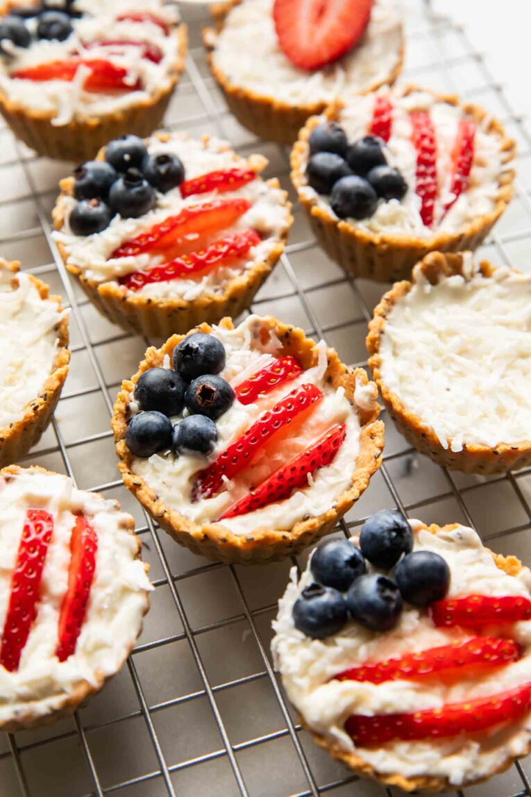 Patriotic fruit tarts on a cooling rack.